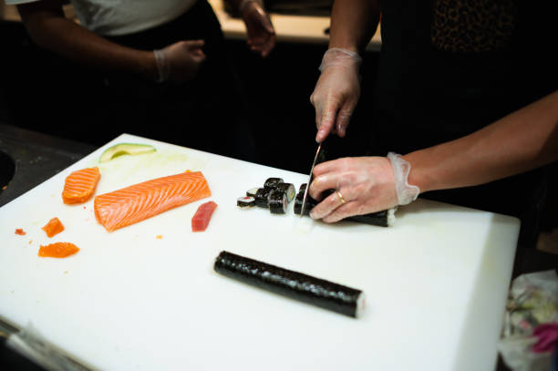 istock Chef cutting sushi rolls in the kitchen 1478774163