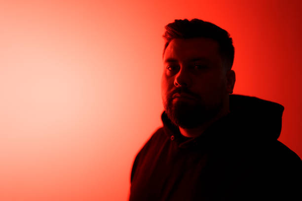 istock Serious bearded man in shadow against neon illumination 1478774371