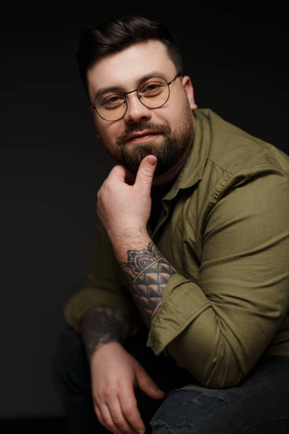 istock Pensive bearded man looking at camera and touching chin 1478774495