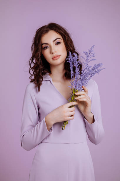 istock Attractive woman with bouquet on lilac background 1478775073