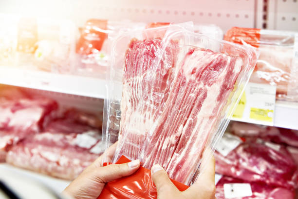 istock Hands with slice of pork meat at store 1478776568