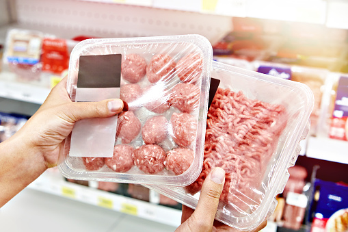 Buyers hands with chopped meat in store