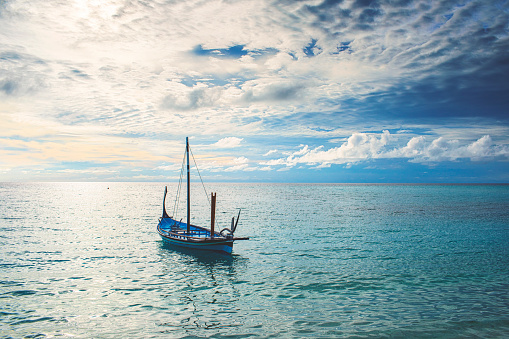 Small beautiful wooden boat on the Indian Ocean at the Maldives