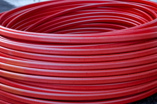Twisted rubber red hose coiled. Household goods.