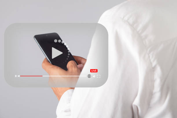 istock Male hand-holding smart phone with video player icon. 1478781039