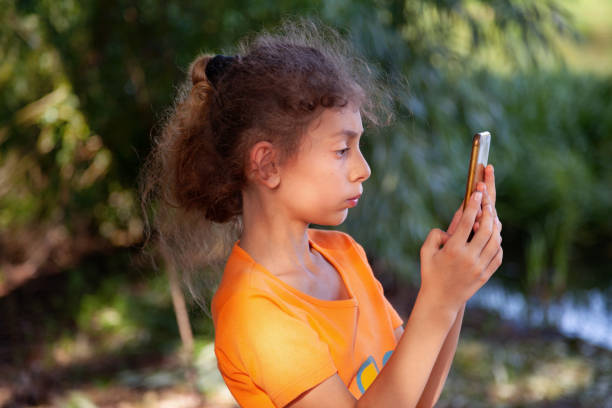 Side view of a child looking at the smartphone