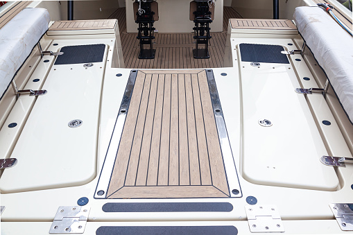 Deck of a luxury modern yacht with closed hatches and steps.
