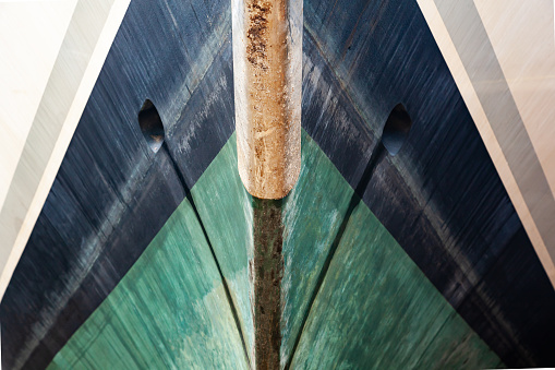 The bow of the yacht, bottom view, close-up. The waterline is clearly visible. Front of a luxury yacht.