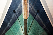 The bow of the yacht, bottom view, close-up. The waterline is clearly visible. Front of a luxury yacht.