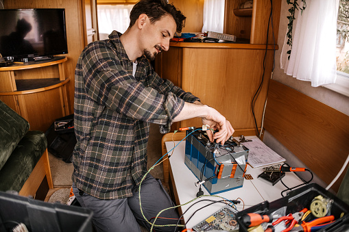 Man fixes the electricity in a caravan