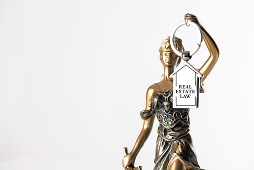 Lady justice holding home keychain.