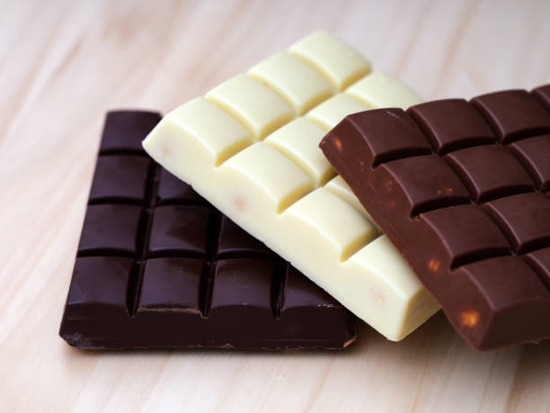 istock Three chocolate bars - milk chocolate, dark chocolate and white chocolate on a wooden background. 1478800949