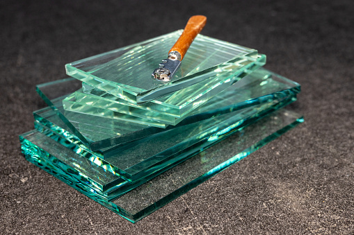 Pieces of thick glass stacked and a specialized glass cutter, Concept, Glazier's work