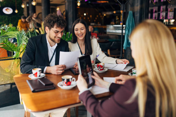 istock Group of business people sitting in modern restaurant working on business plans using digital tablet 1478814272