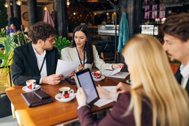 istock Business people sitting in modern restaurant working on business plans using digital tablet and refreshing with hot espresso coffee 1478814276