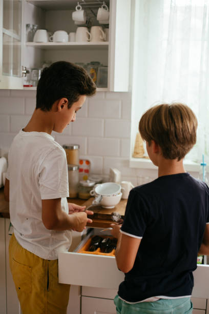 istock Children Taking Off Clean Dishes From The Diswasher 1478814300