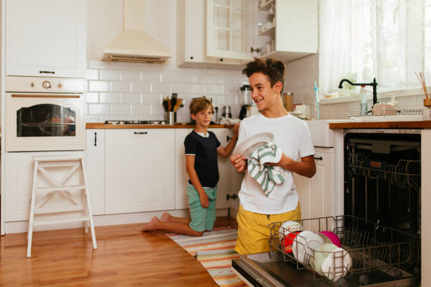 istock Children Taking Off Clean Dishes From The Diswasher 1478815723