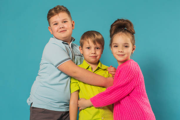 istock Two boys and girl in studio on blue background 1478816379