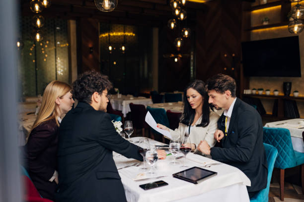 istock Four associates arrange paperwork during a meeting in a restaurant 1478816564