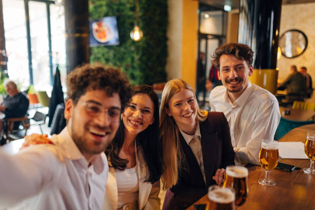istock Four cheerful business people taking selfie at bar after work 1478823839