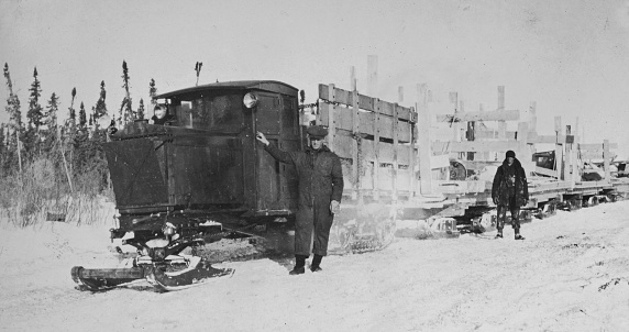 Flin Flon, Manitoba, Canada - February 1928. Men hauling construction materials with Linn Tractors, for the construction of the Canadian National Railway at Flin Flon in Manitoba, Canada. Vintage photograph ca. 1928.