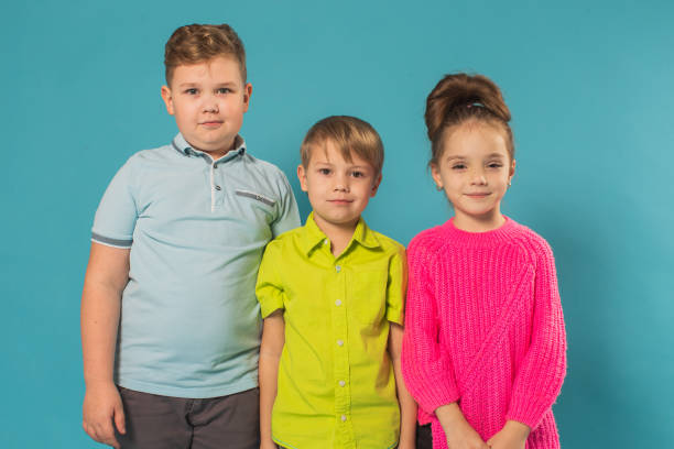 istock Two boys and girl in studio on blue background 1478826010