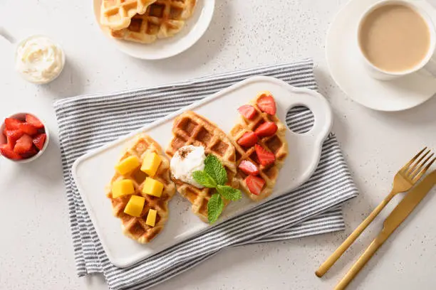 Photo of Tasty breakfast with croffles mango, strawberries. Croissant as waffle.