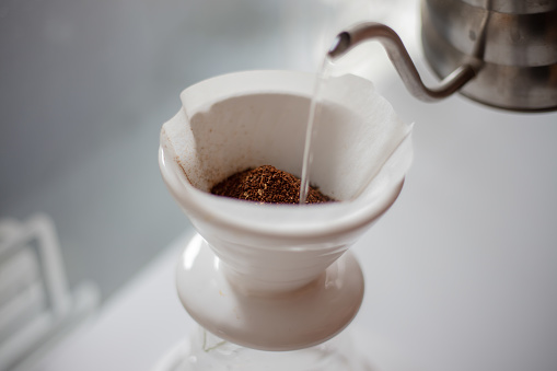 Manual coffe grinder with coffe grains isolated on a white, with copy space.