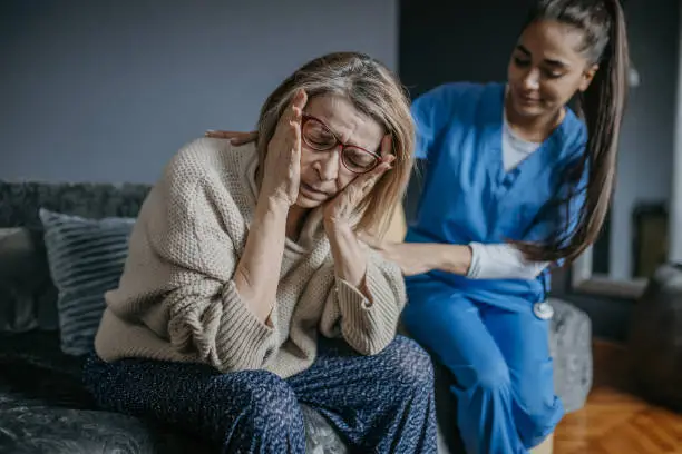 Photo of A worried woman and a nurse during a home visit