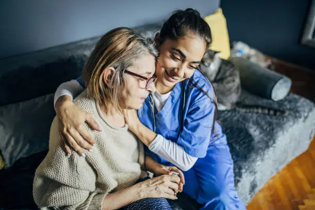 Photo of Young nurse in a home visit to a woman