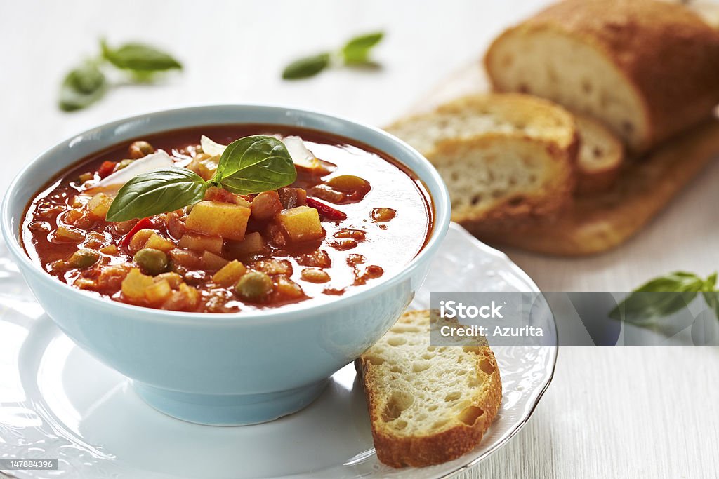 Bowl of minestrone soup with a slice of bread on the side Bowl of minestrone soup with bread Minestrone Stock Photo