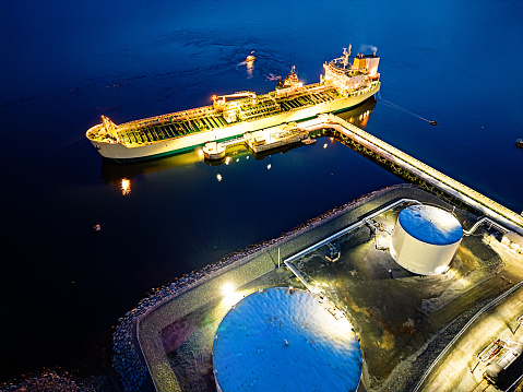 Aerial view of an oil/chemical tanker ship docked at port in twilight.