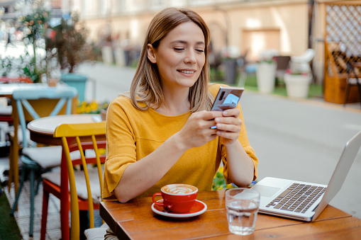 Successful business woman sitting in cafe using mobile phone at a coffee shop