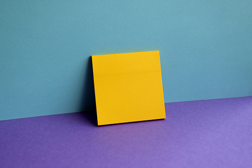 Blank adhesive paper on colored background