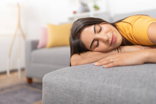 istock Young lady, sleeping peacefully lying on her stomach on the sofa 1478880472
