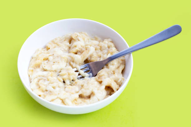 istock Mashed bananas in bowl on green background. 1478881399