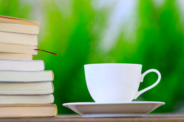 Stacked books and white coffee cup