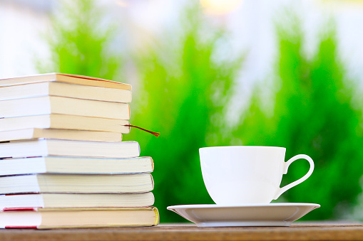Stacked books and white coffee cup