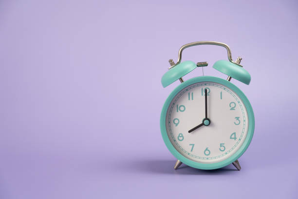 istock Retro alarm clock on purple table background, vintage style, flat lay 1478898053
