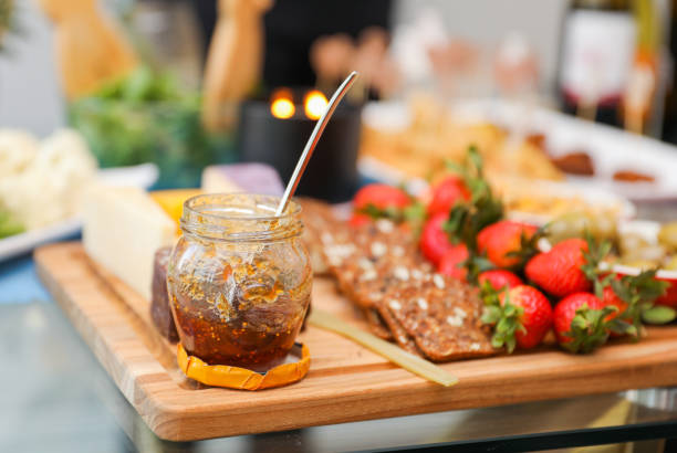 elegantly arranged charcuterie board displaying various meats, cheeses, fruits, and nuts. It symbolizes the joy of abundance and shared experiences, emphasizing the importance of enjoying life