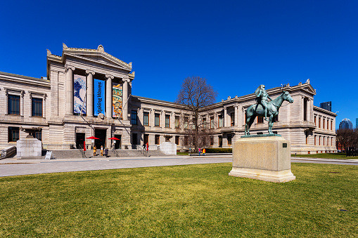 Boston, Massachusetts, USA - March 29, 2023: The Museum of Fine Arts (abbreviated as MFA Boston or MFA) is an art museum in Boston. It is the 20th-largest art museum in the world, measured by public gallery area. It contains 8,161 paintings and more than 450,000 works of art, making it one of the most comprehensive collections in the Americas. Founded in 1870 in Copley Square, the museum moved to its current Fenway location in 1909. In front of the Museum of Fine Arts building is the Appeal to the Great Spirit, a 1908 equestrian statue by Cyrus Dallin. It portrays a Native American on horseback facing skyward, his arms spread wide in a spiritual request to the Great Spirit.