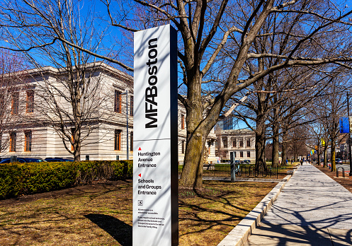 Boston, Massachusetts, USA - March 29, 2023: The Museum of Fine Arts (abbreviated as MFA Boston or MFA) is an art museum in Boston. It is the 20th-largest art museum in the world, measured by public gallery area. It contains 8,161 paintings and more than 450,000 works of art, making it one of the most comprehensive collections in the Americas. Founded in 1870 in Copley Square, the museum moved to its current Fenway location in 1909. Sign along Huntington Avenue.