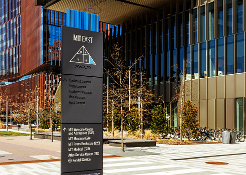 Cambridge, Massachusetts, USA - March 30, 2023: A directional sign post with arrows pointing to various buildings on MIT's East campus.