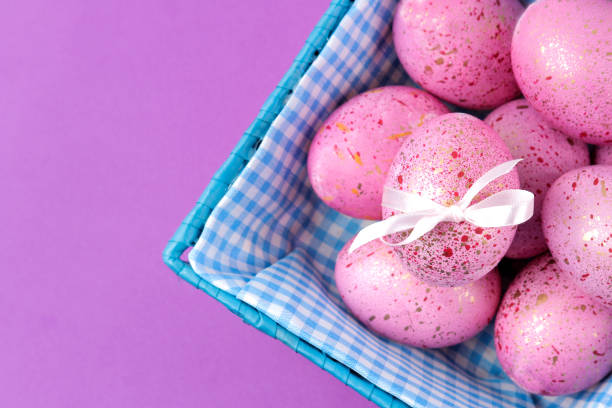 istock Easter. Pink Easter eggs in a basket on a trendy lilac background. Happy easter. holidays. top view 1478913582