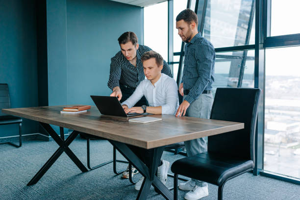istock Professional young adults in the workplace working diligently on their laptops in a team 1478913851