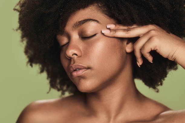 istock Young black female millennial touching face in green studio 1478914047
