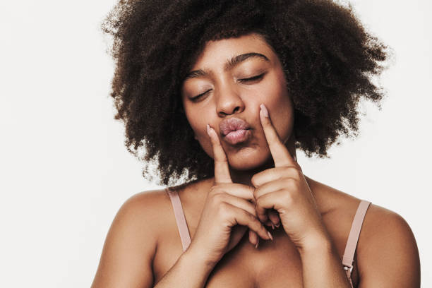 istock Happy young black woman pouting lips against white background 1478914105