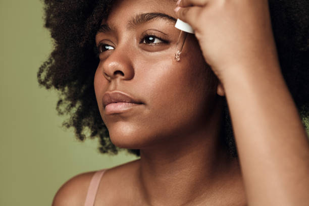 istock Black woman applying cream on face 1478914199
