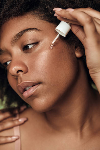 istock Black woman applying serum on face 1478914205