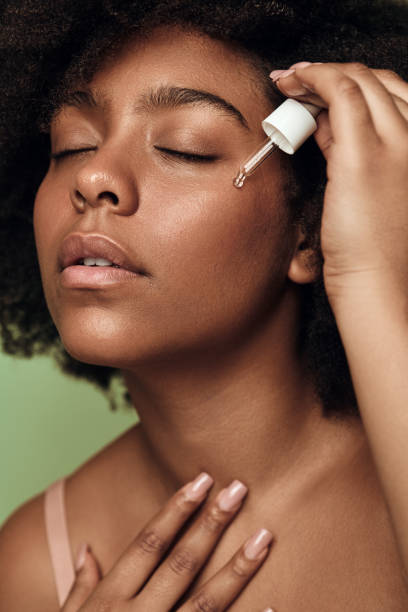 Young black woman using serum stock photo